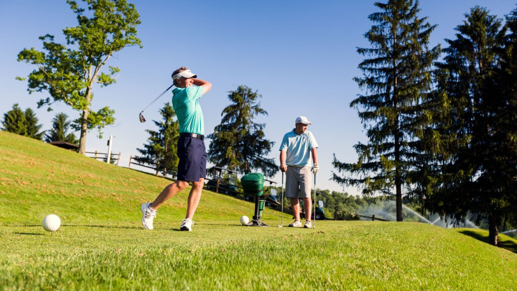 Golfers taking a swing on golf course